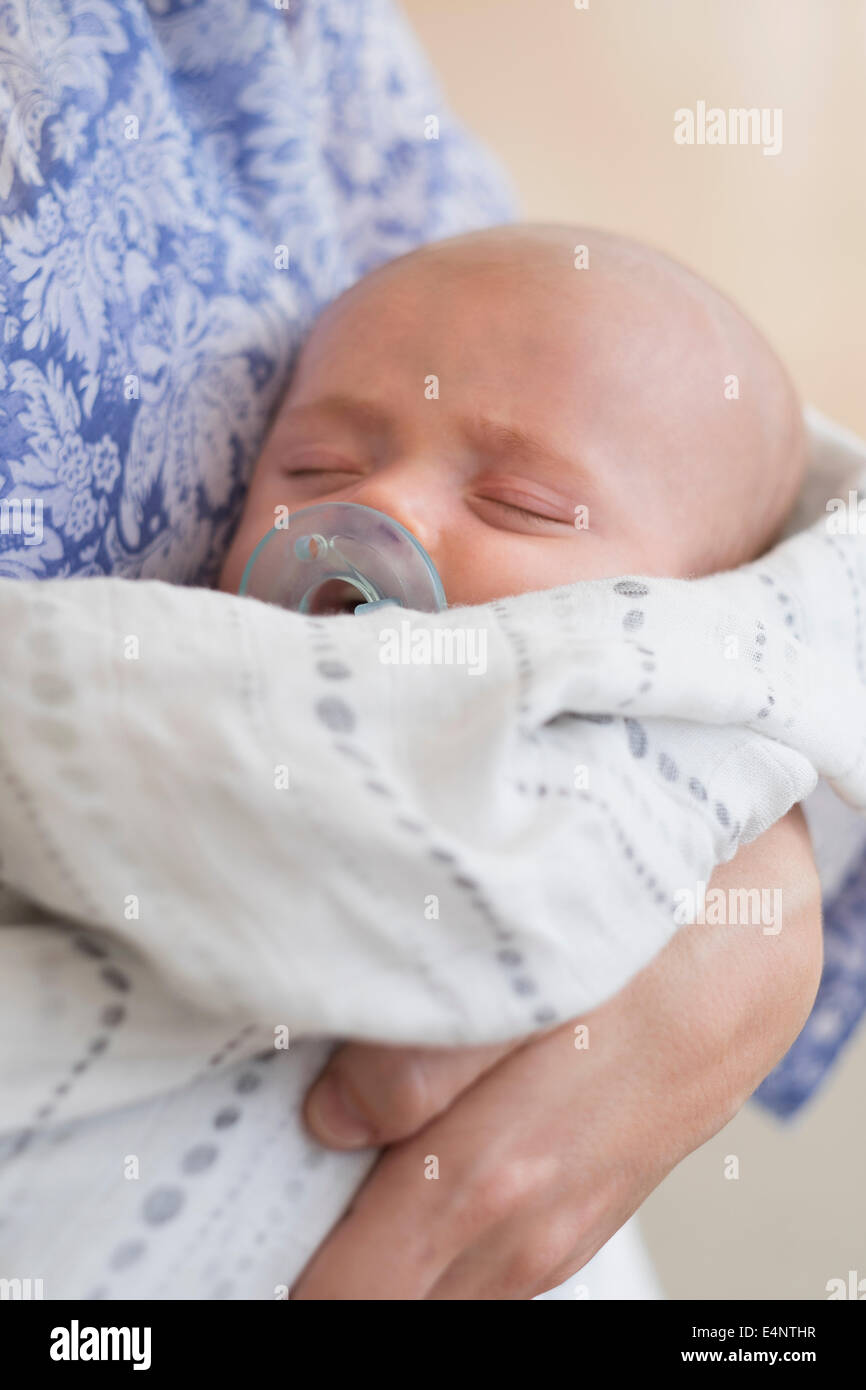 Close up of Baby Boy (2-5 months) sleeping in mother's arms Banque D'Images