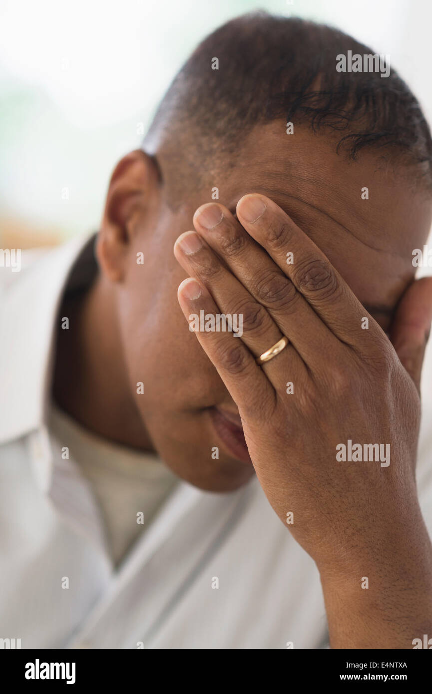 Homme triste couvrant le visage avec la main Banque D'Images