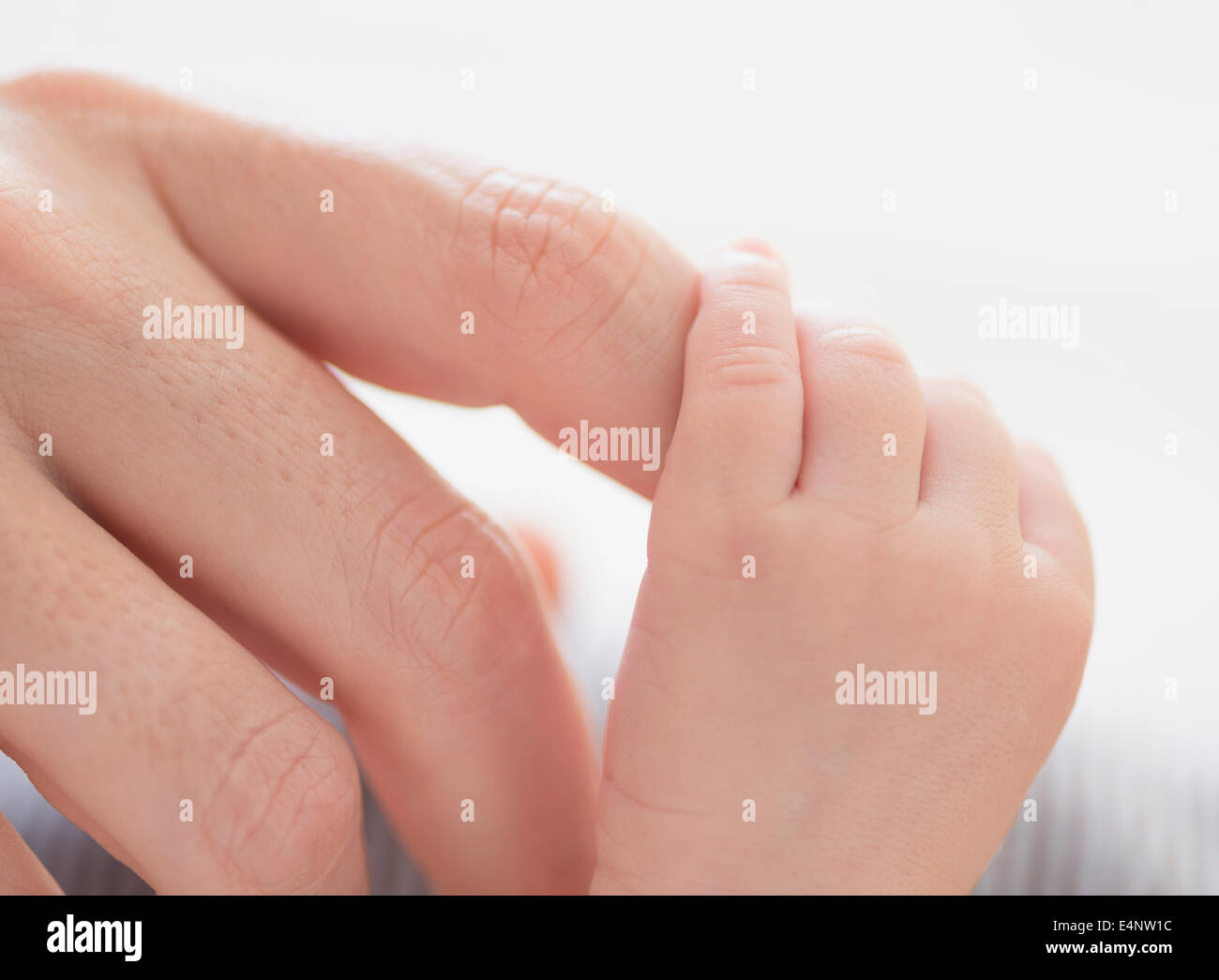 Close up of mother's hand touching Baby Boy's (2-5 mois) foot Banque D'Images