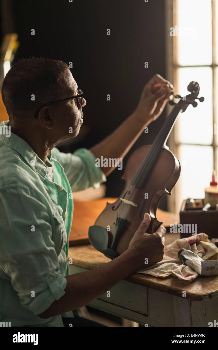 Fixation à l'homme mûr dans son atelier de violon Banque D'Images