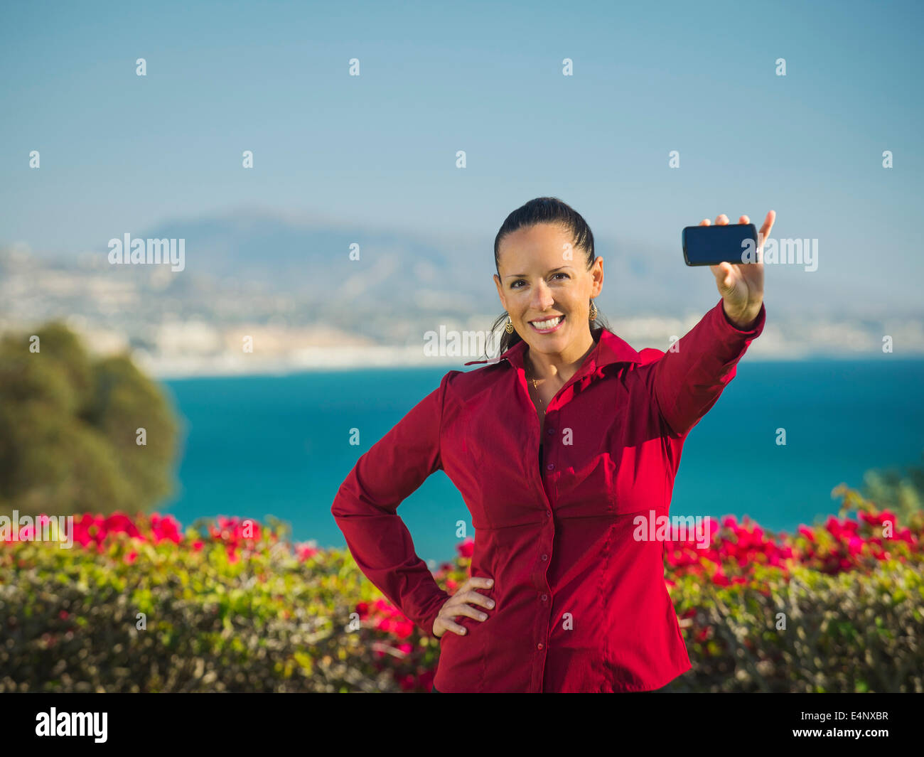États-unis, Californie, Dana Point, Portrait of smiling woman holding smartphone Banque D'Images