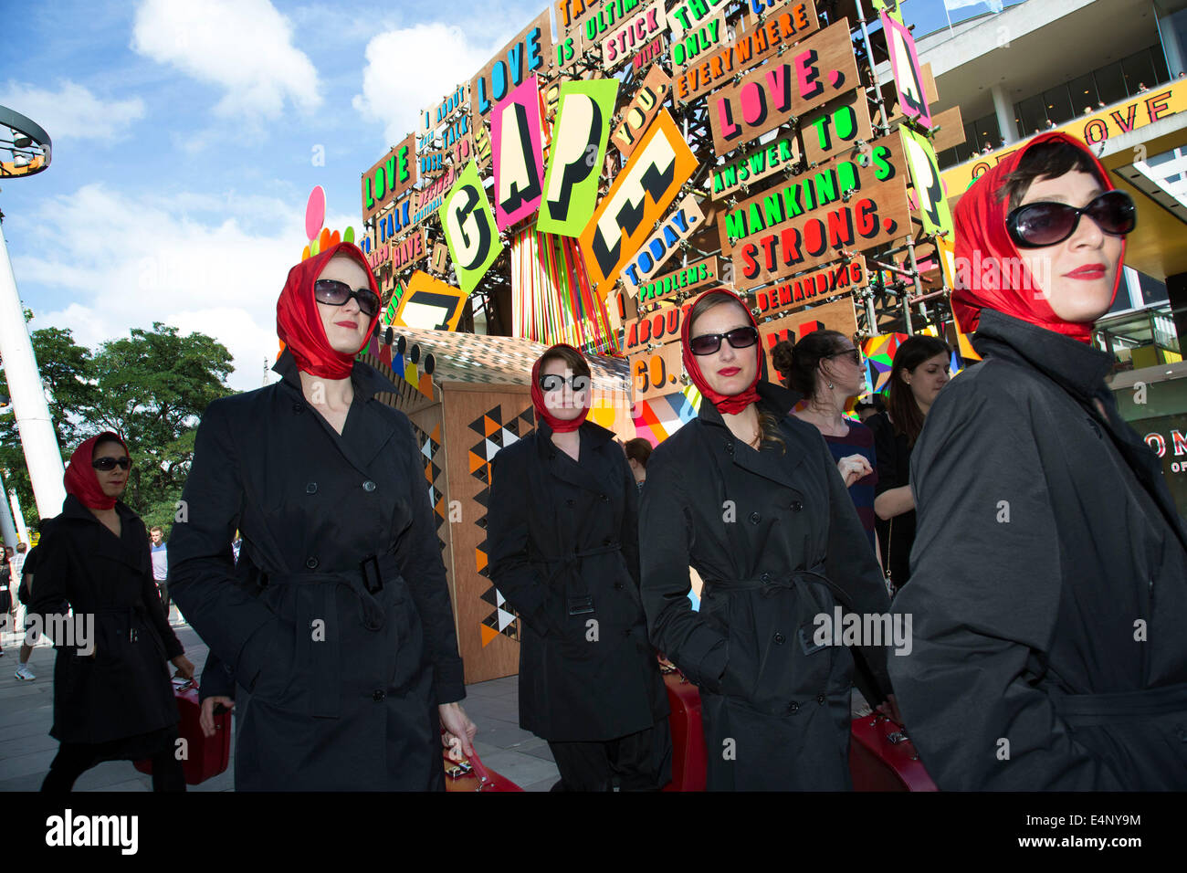 Cinq femmes portant des foulards de tête rouge passer le Festival de l'amour de l'installation. South Bank, Londres, Royaume-Uni. Banque D'Images