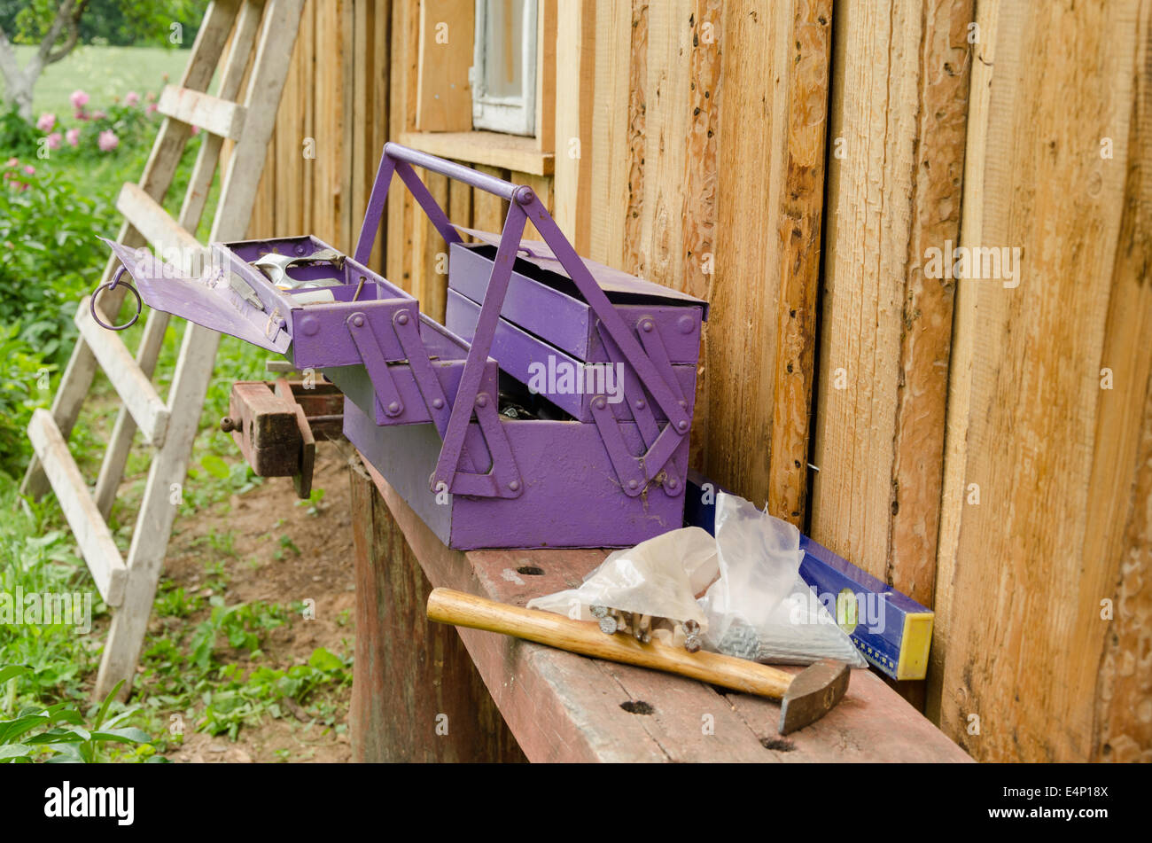 Boîte à outils pourpre et un marteau clou sur table en bois piscine Banque D'Images