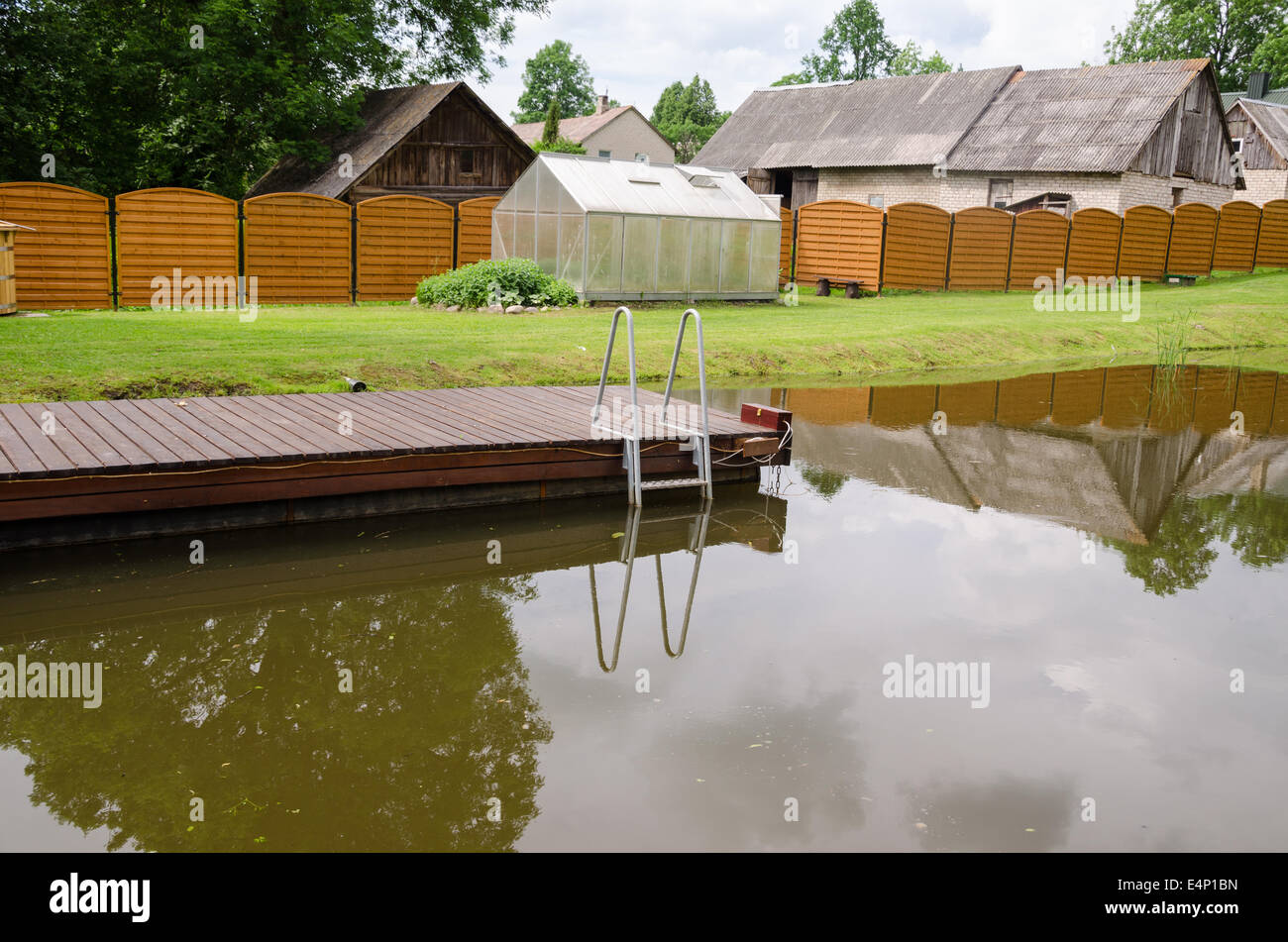 Étang de jardin avec une longue passerelle flottante Banque D'Images