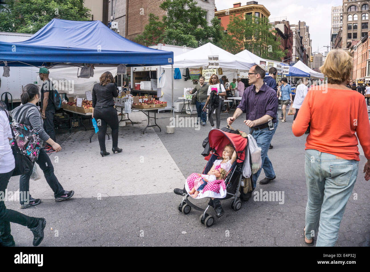 Papa juifs portant kippa pousse jolie fille dans la poussette passé shoppers multiculturelle & stands débordant de produire Banque D'Images
