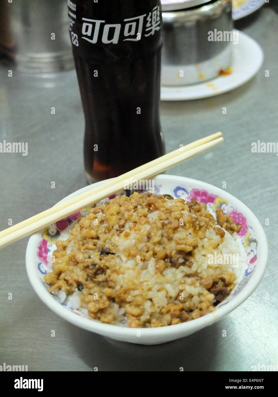 Coca Cola et un plat de riz sur une table en acier inoxydable dans un restaurant typique à Taiwan. Banque D'Images