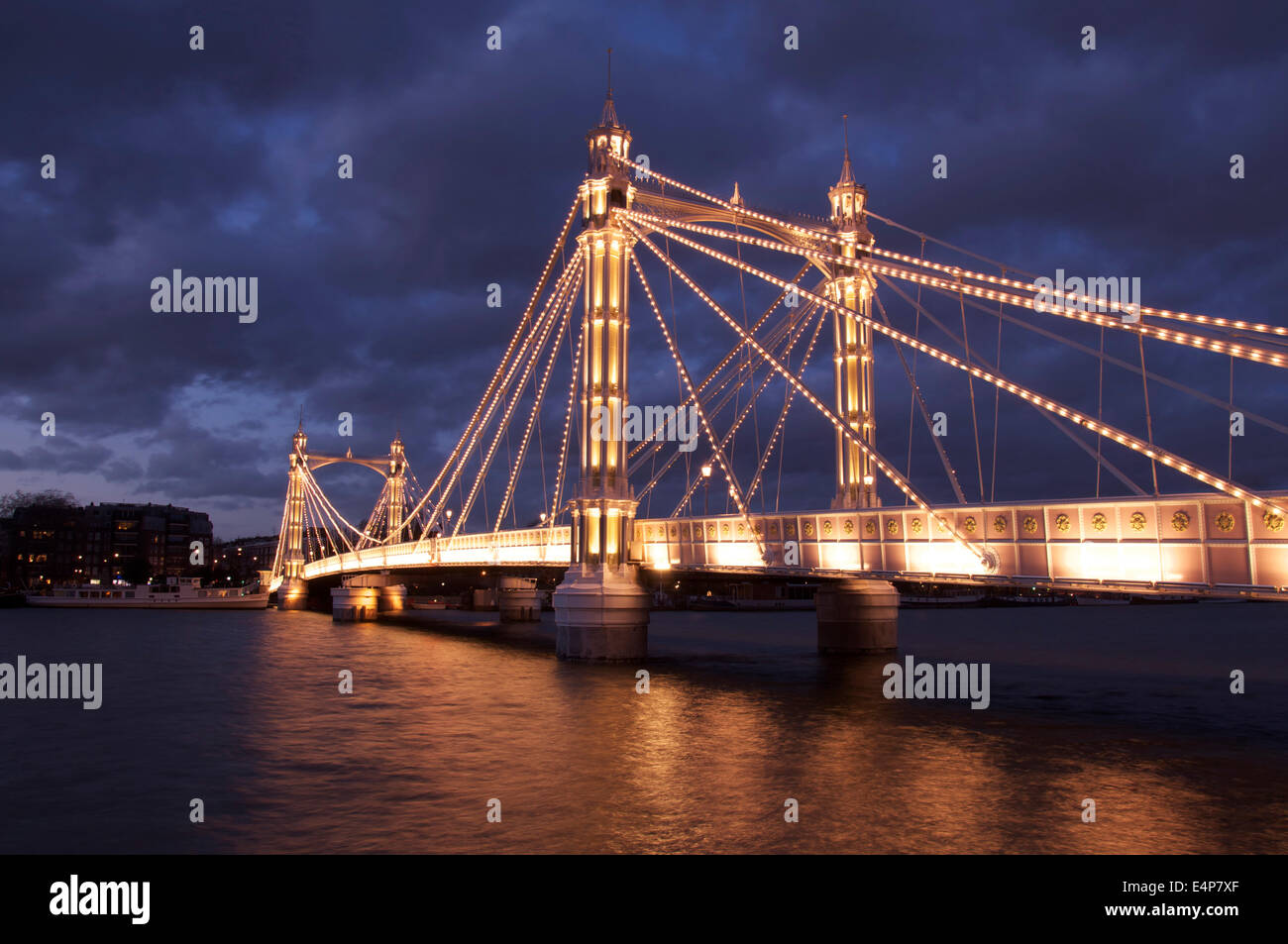La lumineuse splendeur victorienne d'Albert Bridge, allumé à la tombée de la nuit, en traversant la Tamise entre Battersea et Chelsea. Londres, Angleterre. UK. Banque D'Images