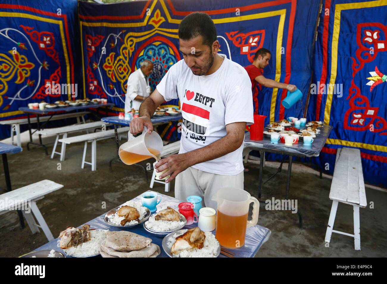 Le Caire, Égypte. 15 juillet, 2014. Un homme prépare des repas pour un banquet de bienfaisance au Caire, Égypte, le 15 juillet 2014. La charité des banquets, ou ma'idat al-Rahman, représentent une longue tradition du Ramadan en Egypte, par lequel riches patrons fournissent leurs moins riches coreligionnaires avec les repas pour rompre le jeûne. © Cui Xinyu/Xinhua/Alamy Live News Banque D'Images