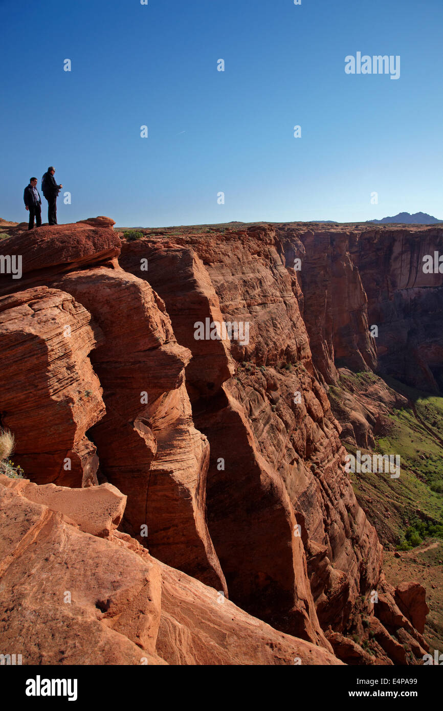Les touristes à la recherche à 1000 ft tomber à la rivière Colorado à Horseshoe Bend, juste en dehors de Grand Canyon, près de Page, Arizona, USA Banque D'Images