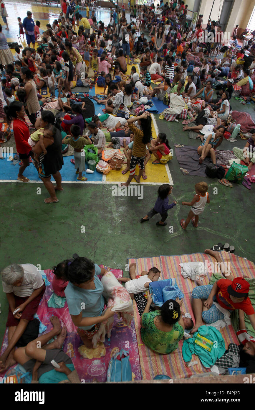 Manille, Philippines. 16 juillet, 2014. Les habitants s'abritent dans une cour couverte après l'évacuation de leurs maisons comme typhon Rammasun batters Manille, Philippines, le 16 juillet 2014. Au moins 5 personnes ont été tuées à la suite de l'assaut du typhon Rammasun (nom local : Glenda) qui a paralysé la capitale des Philippines, de Manille, mercredi. Credit : Rouelle Umali/Xinhua/Alamy Live News Banque D'Images