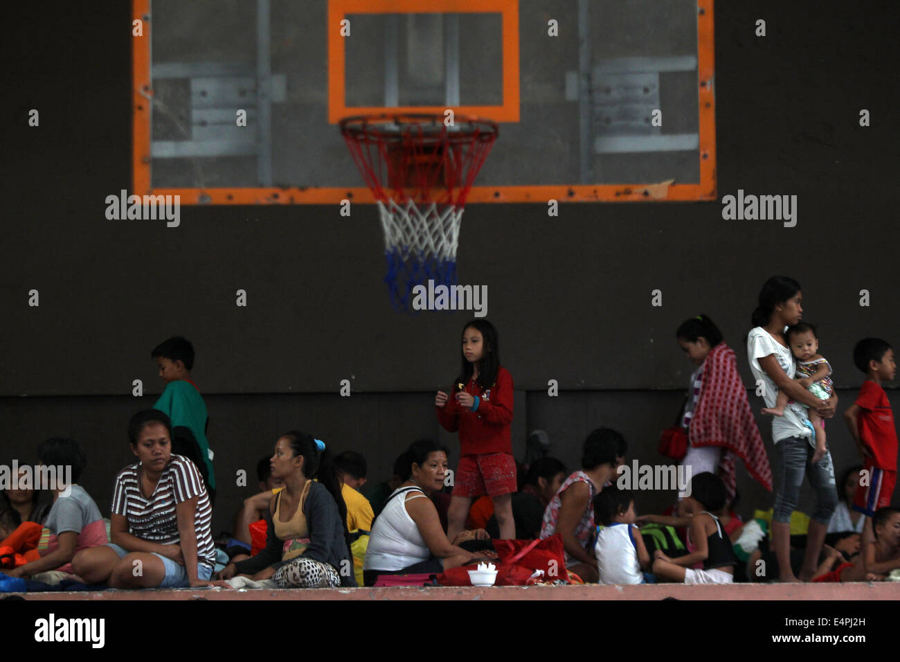 Manille, Philippines. 16 juillet, 2014. Les habitants s'abritent dans une cour couverte après l'évacuation de leurs maisons comme typhon Rammasun batters Manille, Philippines, le 16 juillet 2014. Au moins 5 personnes ont été tuées à la suite de l'assaut du typhon Rammasun (nom local : Glenda) qui a paralysé la capitale des Philippines, de Manille, mercredi. Credit : Rouelle Umali/Xinhua/Alamy Live News Banque D'Images