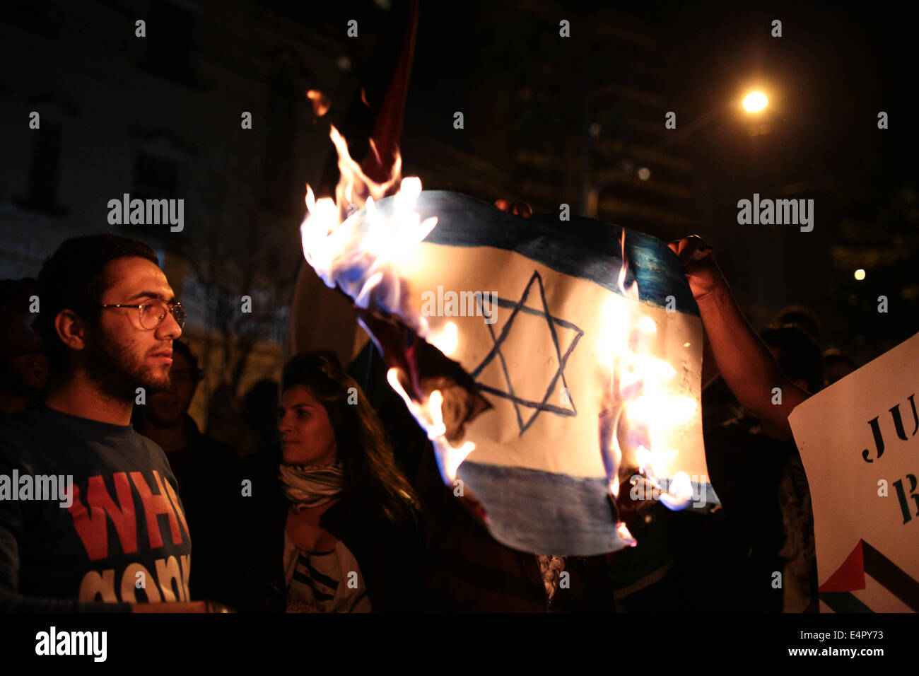 Sao Paulo, Brésil. 15 juillet, 2014. Les partisans de la cause palestinienne brûler un drapeau d'Israël au coeur d'une rue à Sao Paulo, Brésil au cours d'une veillée aux chandelles en soutien au peuple palestinien. La Veillée a été organisée par les Palestiniens et d'autres partisans résidant au Brésil condamnant le martèlement continu israéliens à Gaza. Credit : Tiago Mazza Chiaravalloti/Pacific Press/Alamy Live News Banque D'Images