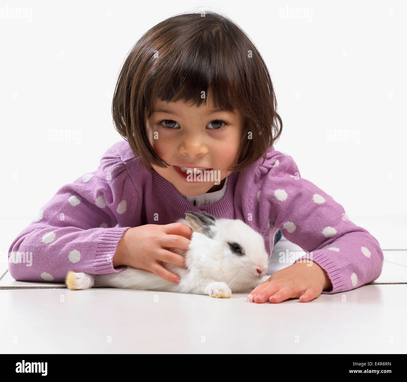 Fille (2 ans) avec bébé lapin blanc Banque D'Images