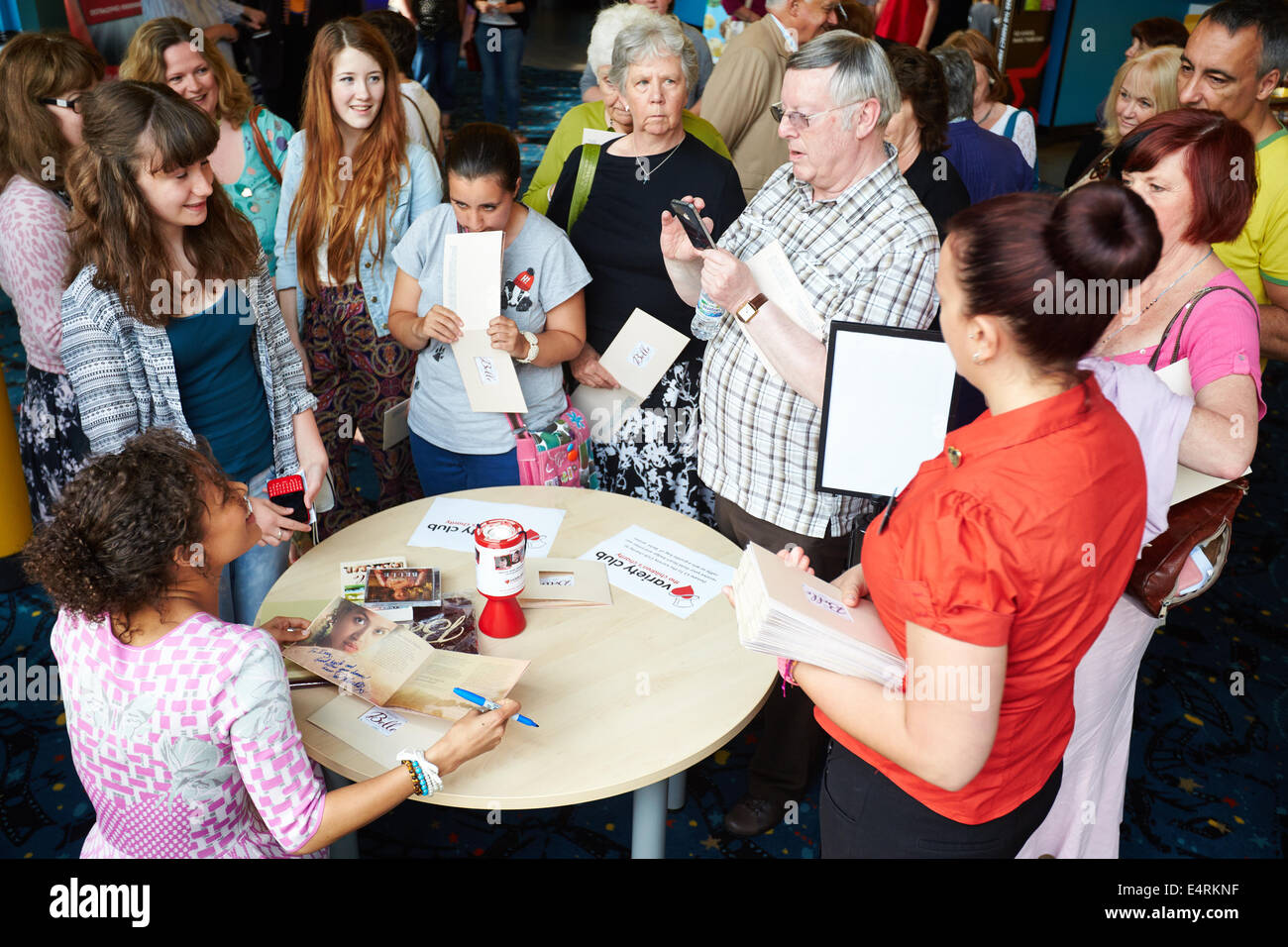 Gugu Mbatha-Raw (assis) de signer des autographes à Witney en amont d'une projection spéciale de son dernier film Belle Banque D'Images