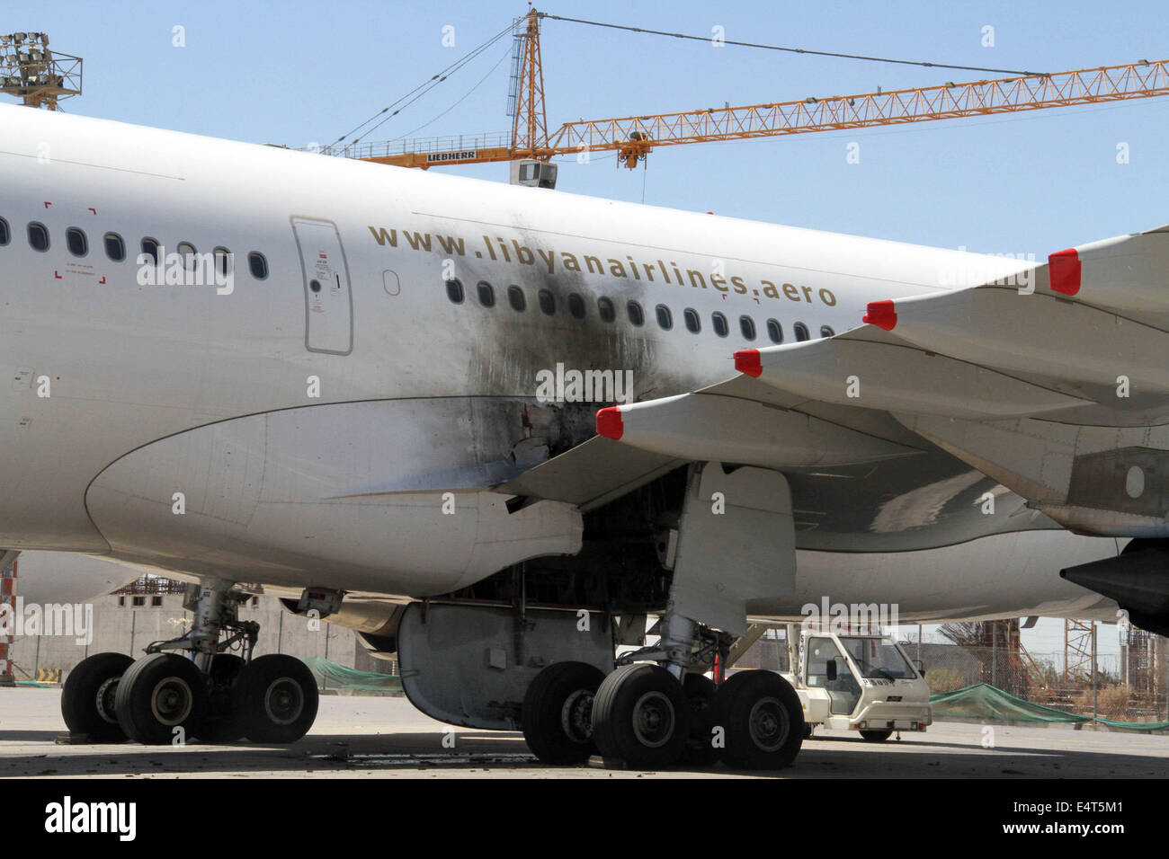 Tripoli. 16 juillet, 2014. La photo prise le 16 juillet 2014 montre un appareil endommagé sur le tarmac de l'Aéroport International de Tripoli, en Libye. L'aéroport international de la Libye dans la capitale Tripoli a été renouvelé en vertu de l'attaque de mercredi avec le nombre de victimes atteint 30, selon des sources de sécurité. Credit : Hamza Turkia/Xinhua/Alamy Live News Banque D'Images