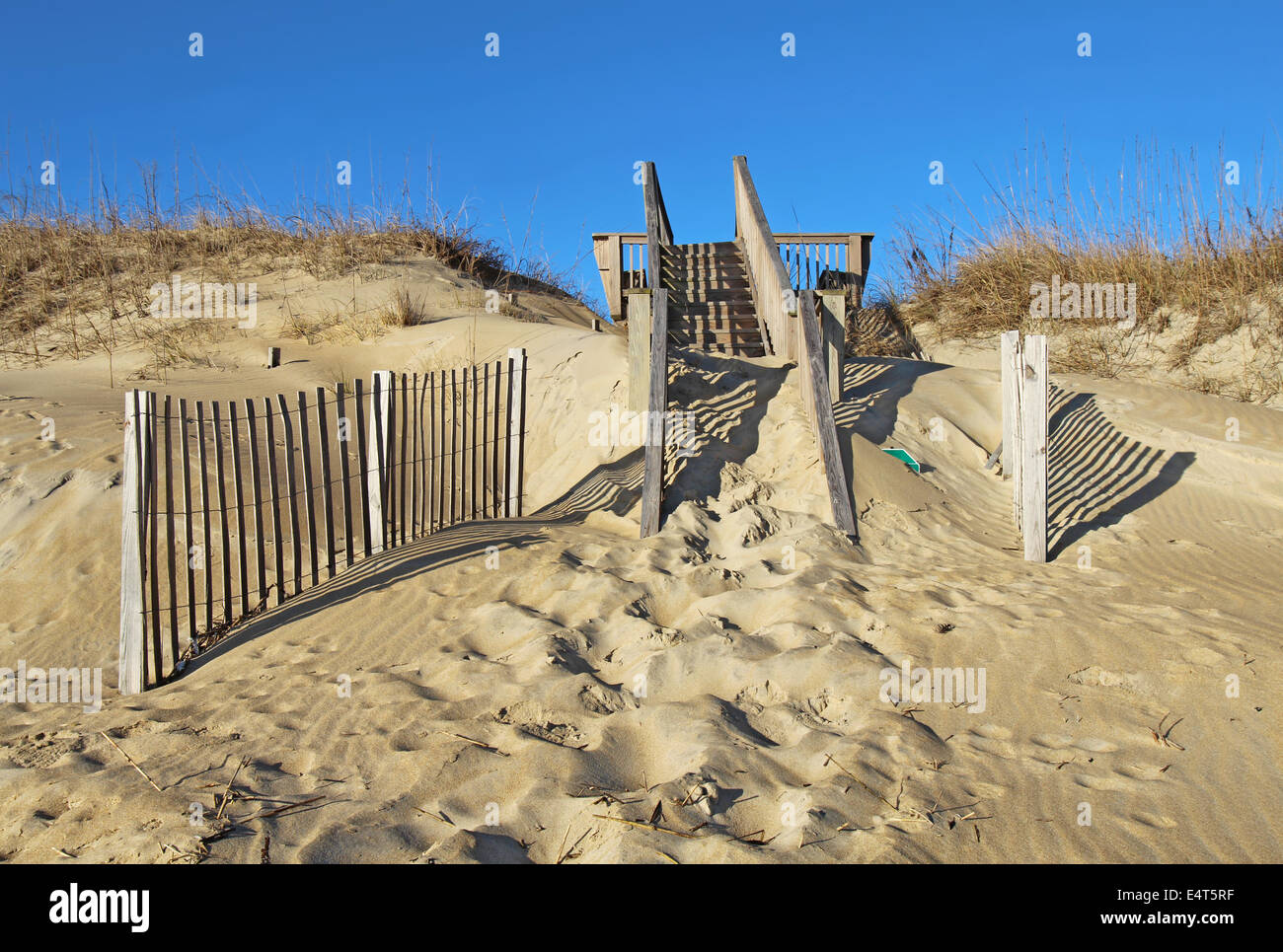 Délabrés, couvertes de sable à un escalier plage publique de Nags Head sur l'Outer Banks de la Caroline du Nord contre un ciel bleu Banque D'Images