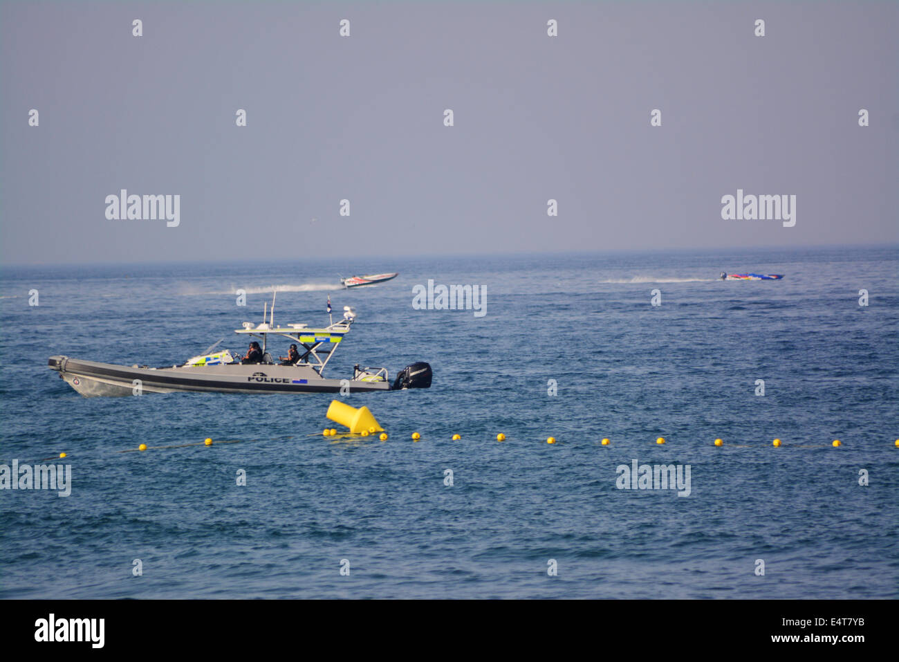 Gibraltar, 16 juillet 2014 - Un navire de patrouille de la police Royal Gibraltar observe alors que l'espagnol hors-bords entrez les eaux de Gibraltar vers le sud de l'Espagne. Filtre Double contrôles maritimes étaient en place sur le côté est de Gibraltar comme eaux la "Virgen del Carmen" procession maritime a eu lieu à La Linea, l'Espagne, juste à côté des plages du côté est de Gibraltar. Les pêcheurs espagnols ont participé au centre de tensions politiques entre Gibraltar et l'Espagne. Banque D'Images