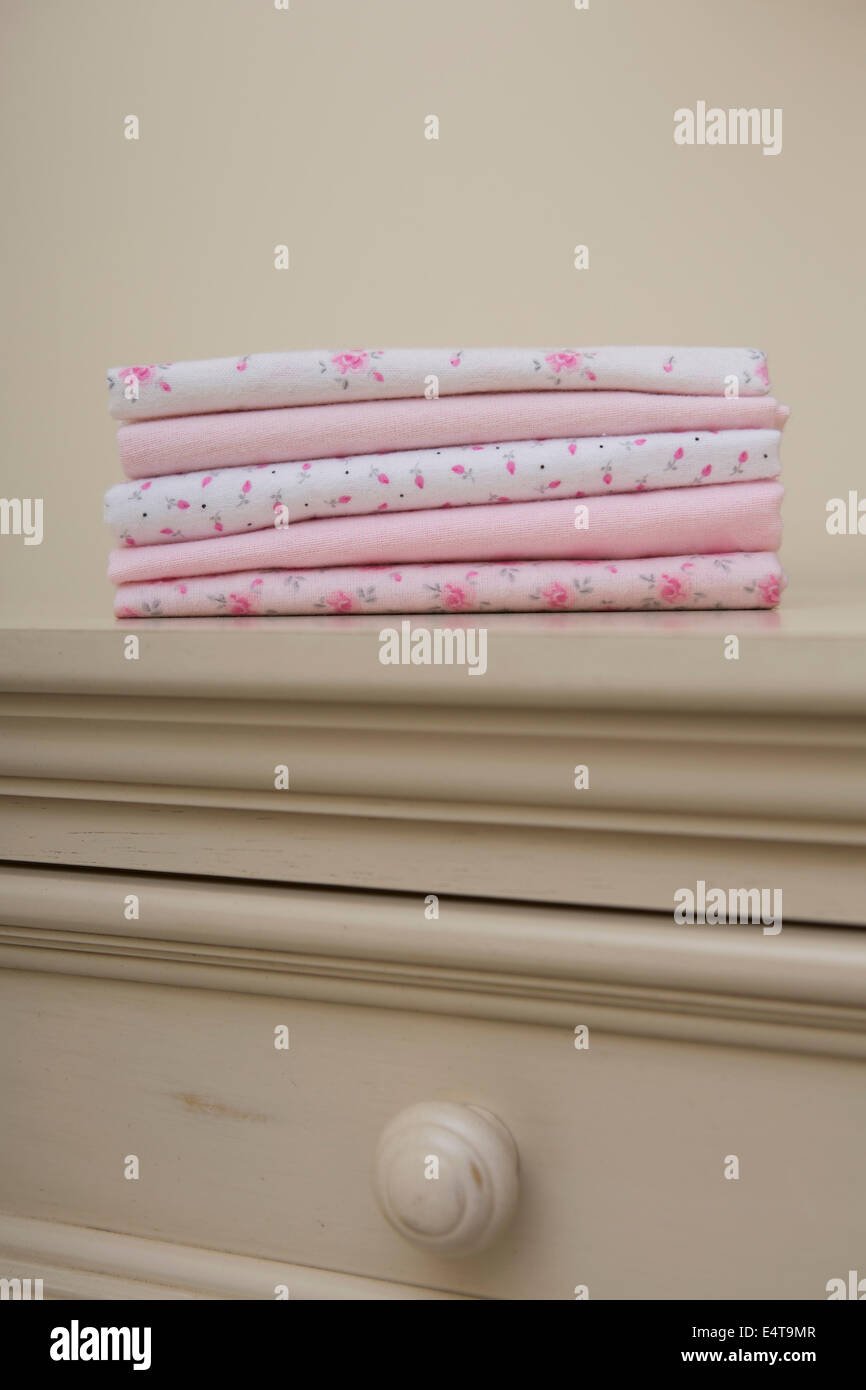 Pile de couvertures pour Bébé rose sur une commode en maternelle Banque D'Images