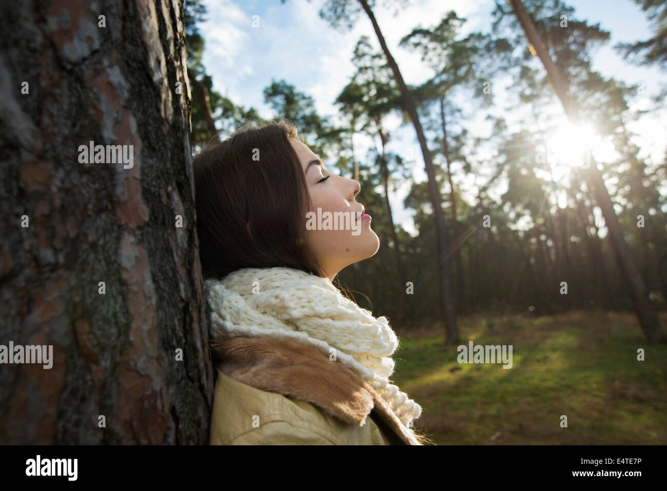 Young Woman Leaning against Tree Trunk, Mannheim, Baden-Wurttemberg, Germany Banque D'Images