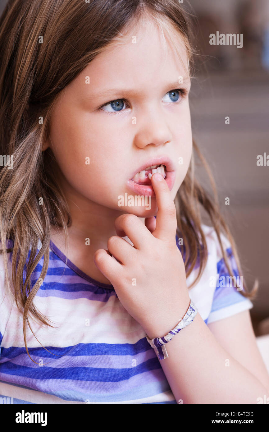 Close-up de fille jouant avec dents desserrées Banque D'Images