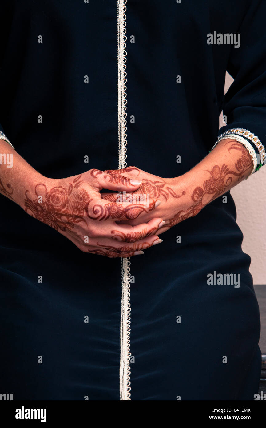 Femme assise avec close-up de plié mains peint avec le henné en style arabe, vêtu de noir, arabe, musulman dress Banque D'Images