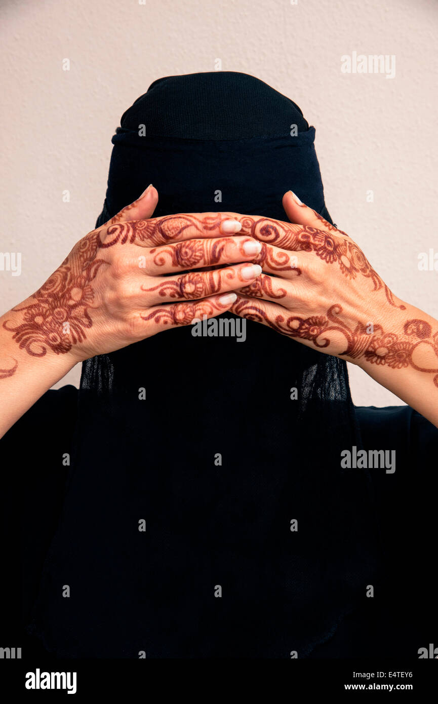 Portrait de femme en noir hijab musulman et musulmane robe, couvrant les yeux et les mains au henné peints dans un style arabe Banque D'Images