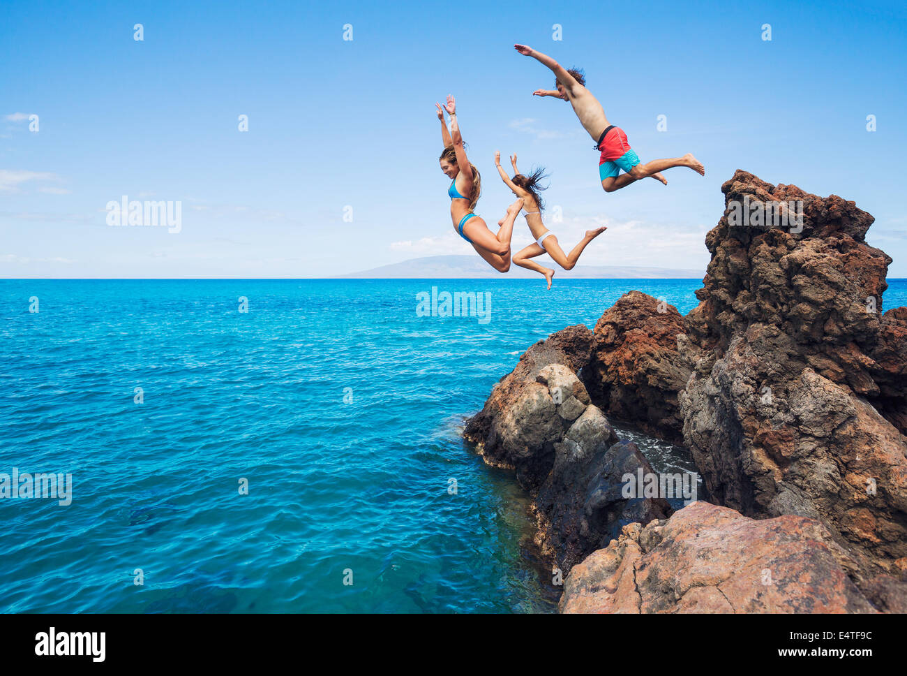 Amis d'été, saut de falaise dans l'océan. Banque D'Images