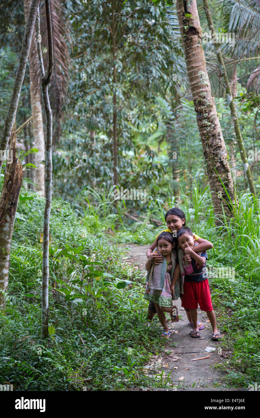 Bali, Indonésie. Les enfants balinais sur un chemin forestier. Banque D'Images