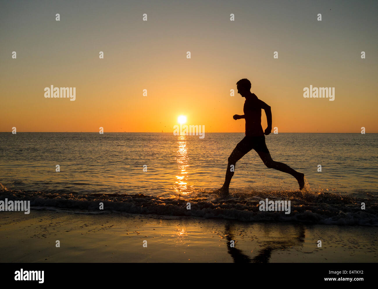 Seaton Carew près de Hartlepool, Angleterre, Royaume-Uni. 17 juillet, 2014. Météo britannique. Jogger sur Seaton Carew beach comme le soleil se lève dans un ciel sans nuages sur une glorieuse jeudi matin sur la côte nord-est. Les températures sont appelées à progresser à 30 degrés Celsius dans le sud-est au cours des deux prochains jours d'orages violents le samedi. Credit : ALANDAWSONPHOTOGRAPHY/Alamy Live News Banque D'Images Seaton Carew près de Hartlepool, Angleterre, Royaume-Uni. 17 juillet, 2014. Météo britannique. Jogger sur Seaton Carew beach comme le soleil se lève dans un ciel sans nuages sur une glorieuse jeudi matin sur la côte nord-est. Les températures sont appelées à progresser à 30 degrés Celsius dans le sud-est au cours des deux prochains jours d'orages violents le samedi. Credit : ALANDAWSONPHOTOGRAPHY/Alamy Live News Banque D'Images