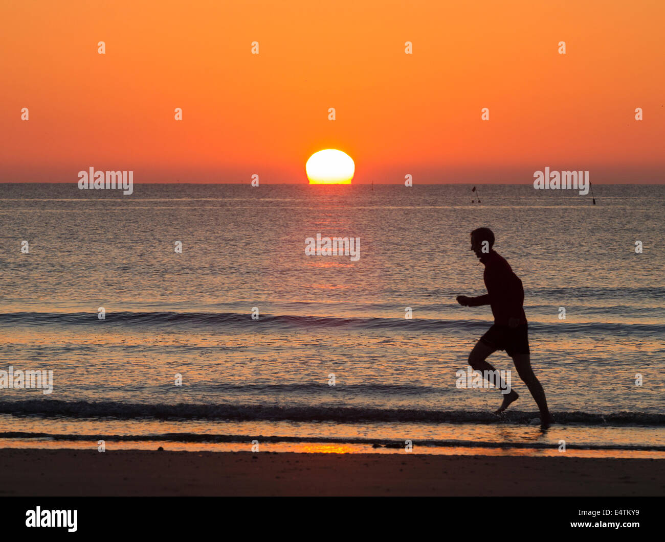 Seaton Carew près de Hartlepool, Angleterre, Royaume-Uni. 17 juillet, 2014. Météo britannique. Jogger sur Seaton Carew beach comme le soleil se lève dans un ciel sans nuages sur une glorieuse jeudi matin sur la côte nord-est. Les températures sont appelées à progresser à 30 degrés Celsius dans le sud-est au cours des deux prochains jours d'orages violents le samedi. Credit : ALANDAWSONPHOTOGRAPHY/Alamy Live News Banque D'Images Seaton Carew près de Hartlepool, Angleterre, Royaume-Uni. 17 juillet, 2014. Météo britannique. Jogger sur Seaton Carew beach comme le soleil se lève dans un ciel sans nuages sur une glorieuse jeudi matin sur la côte nord-est. Les températures sont appelées à progresser à 30 degrés Celsius dans le sud-est au cours des deux prochains jours d'orages violents le samedi. Credit : ALANDAWSONPHOTOGRAPHY/Alamy Live News Banque D'Images