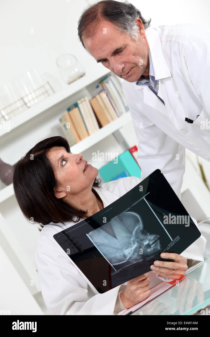 Médecin assistant et regarder une radiographie Banque D'Images