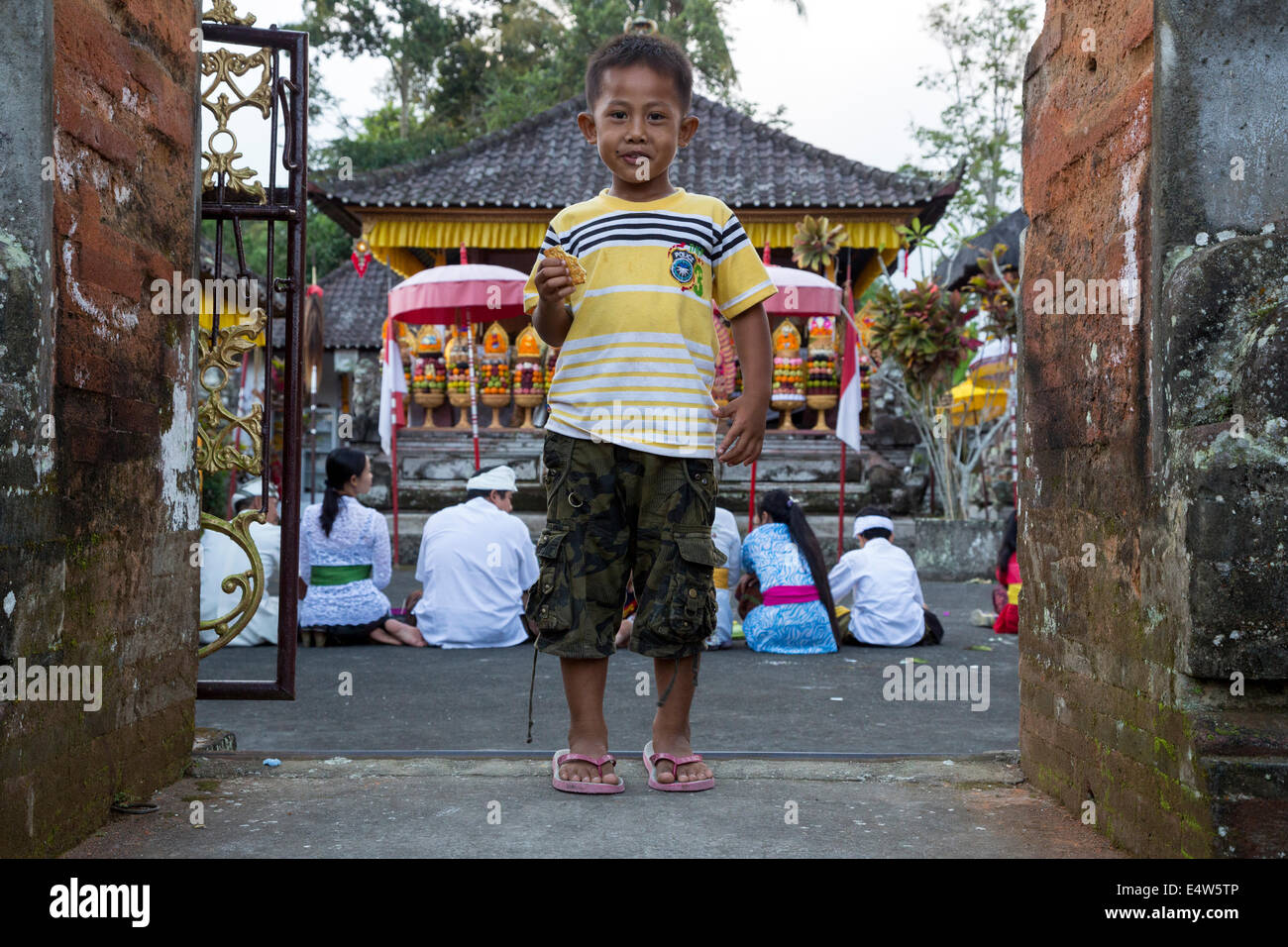 Bali, Indonésie. Peu balinais hindou Boy à l'entrée du temple. Temple Pura Dalem, Blungbang Dlod Village. Banque D'Images
