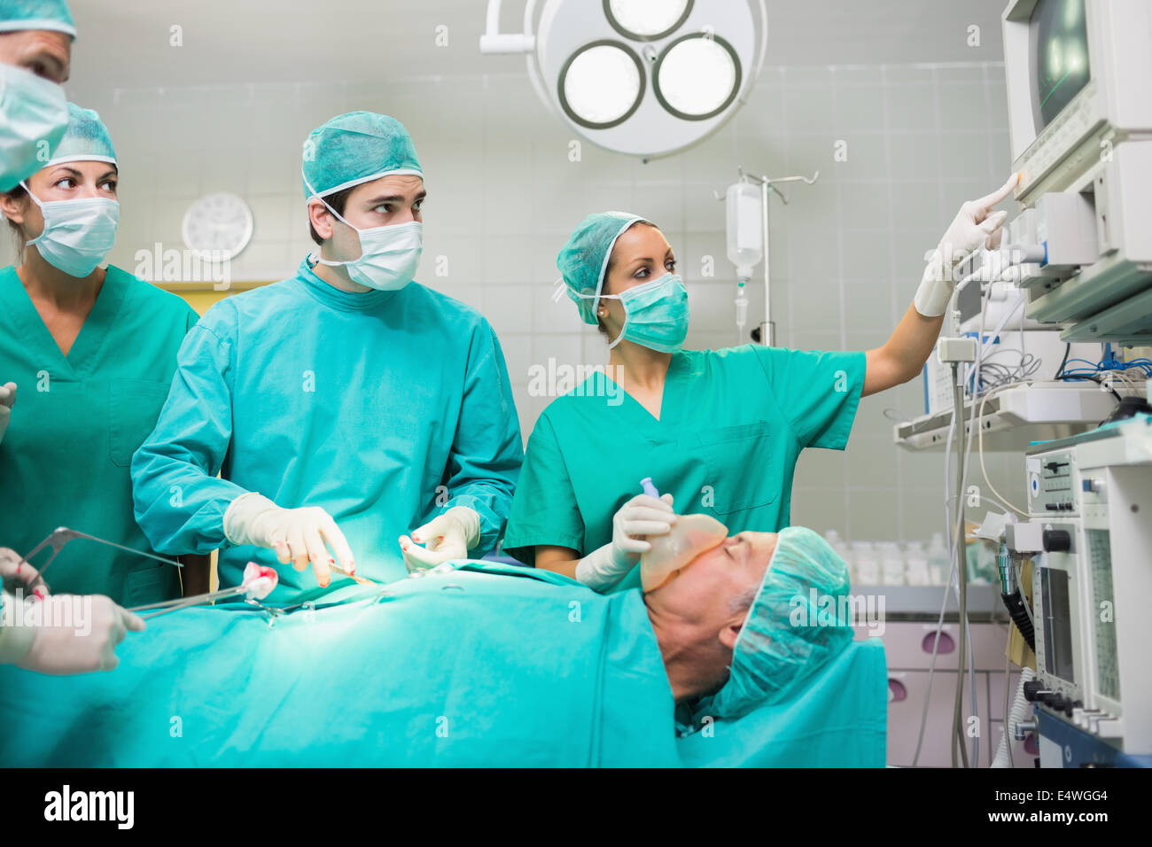 L'équipe chirurgicale à la recherche à un moniteur Banque D'Images