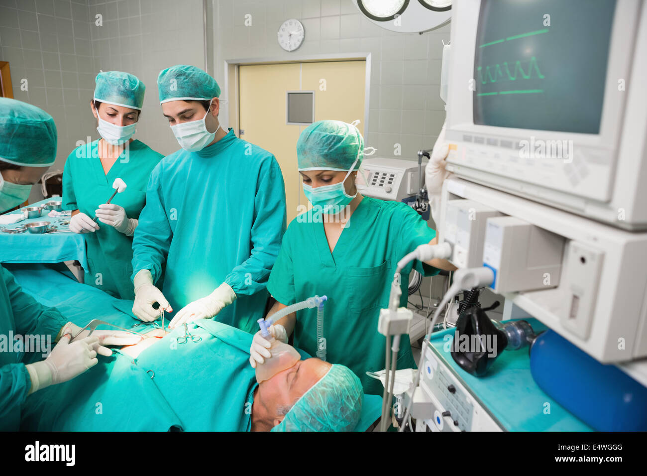 L'équipe chirurgicale à côté d'un moniteur Banque D'Images
