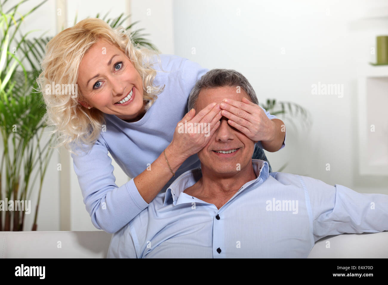 Femme couvrant les yeux de son mari Banque D'Images