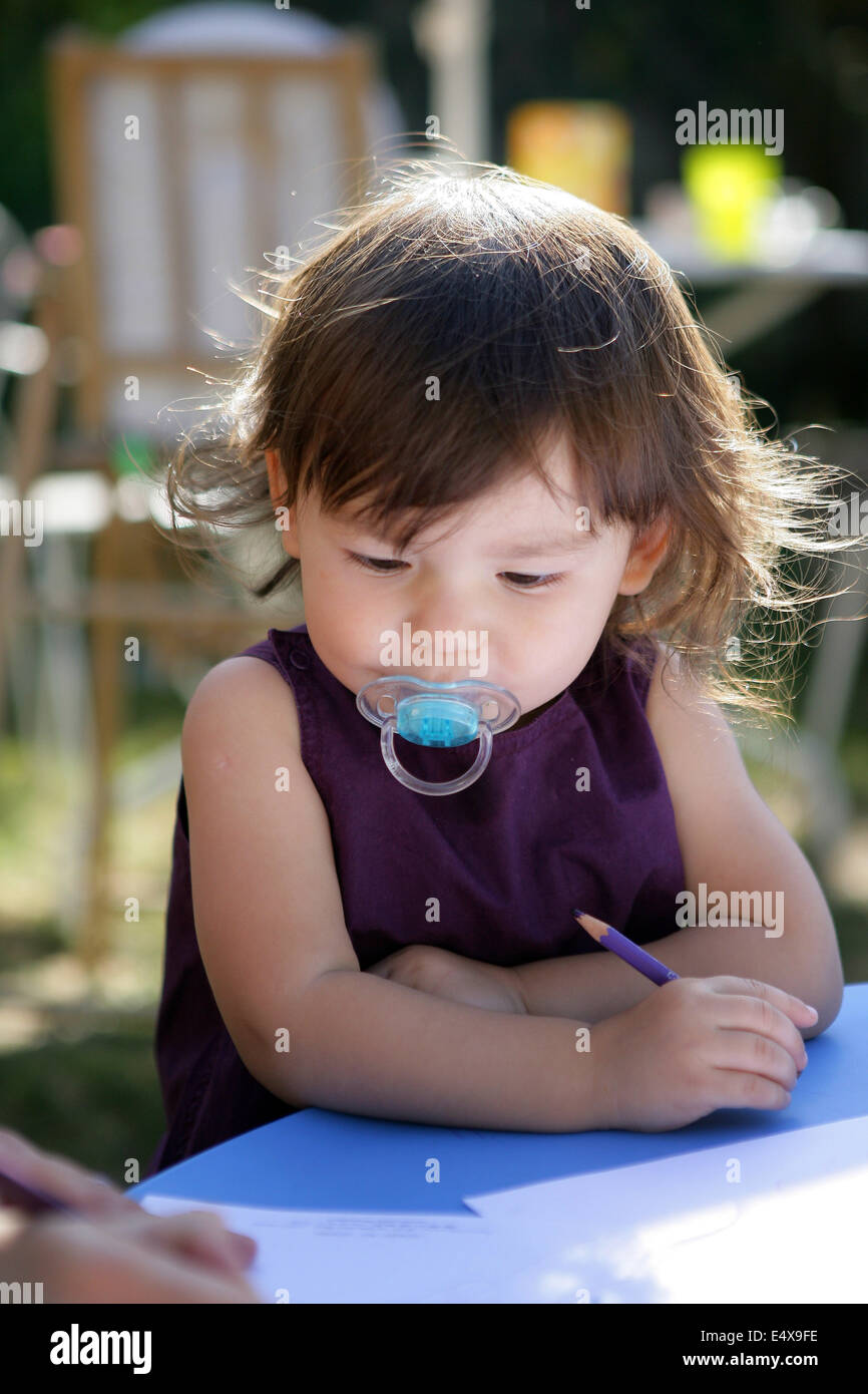 Fille Sittle dessin dans le jardin Banque D'Images