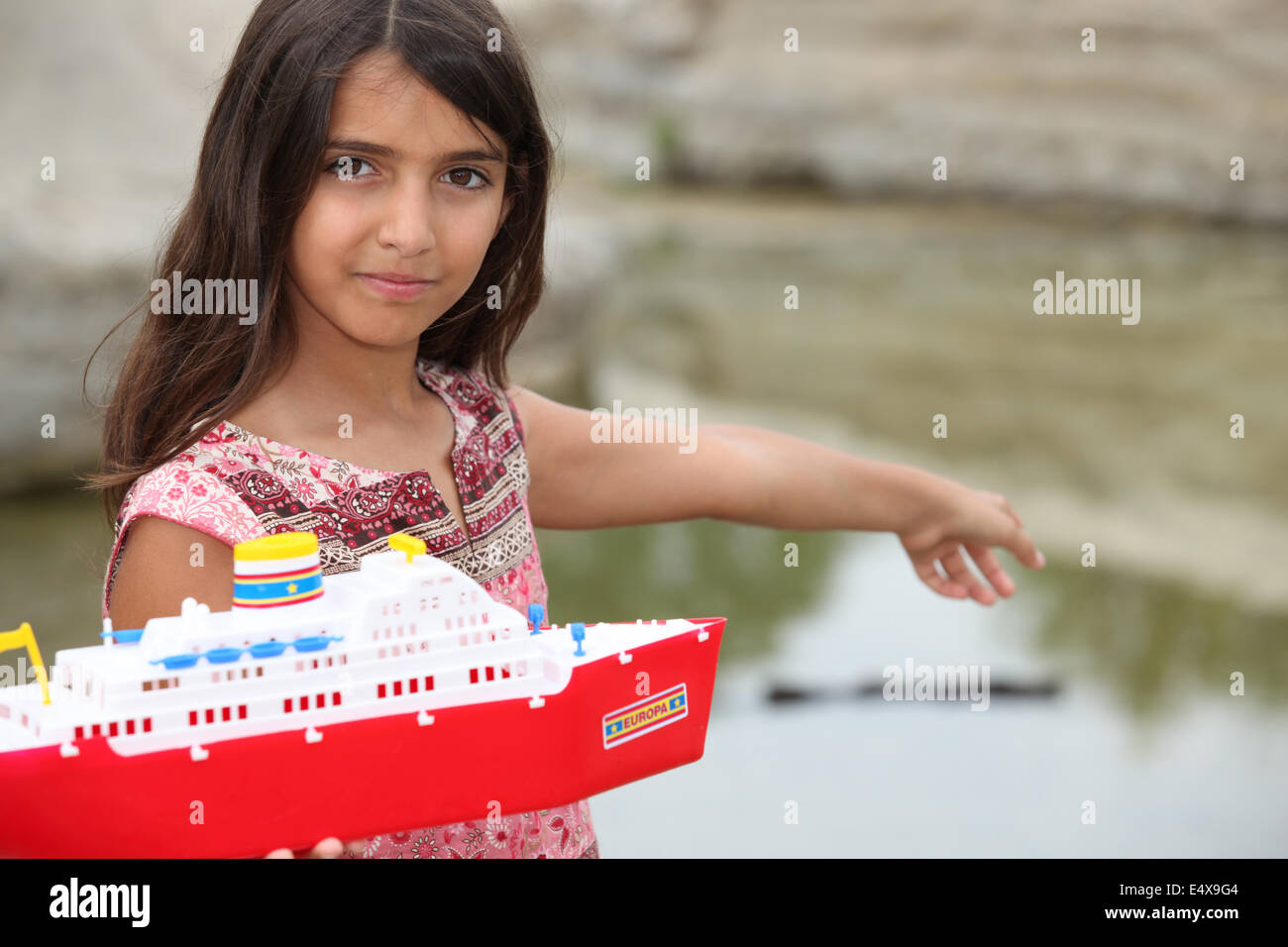 Petite fille jouant avec un bateau jouet Banque D'Images