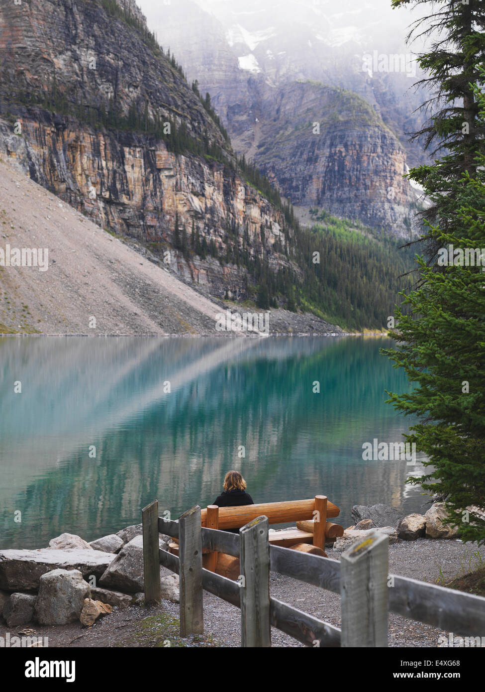 Assis dans la solitude sur un banc de parc au lac Moraine, dans le parc national Banff. La réflexion sur la vie. Banque D'Images
