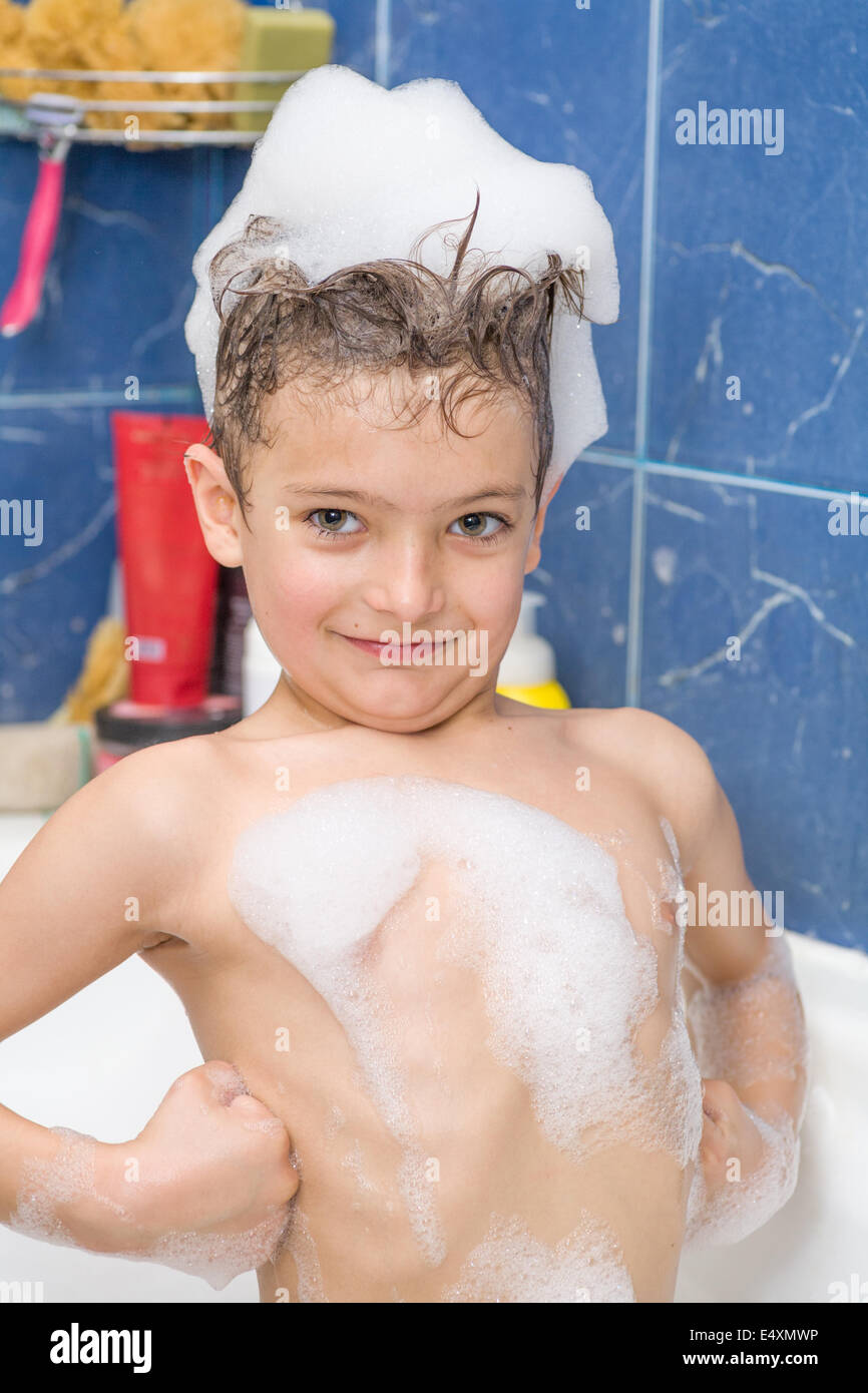 Smiling little boy couvert de bulles de savon Banque D'Images