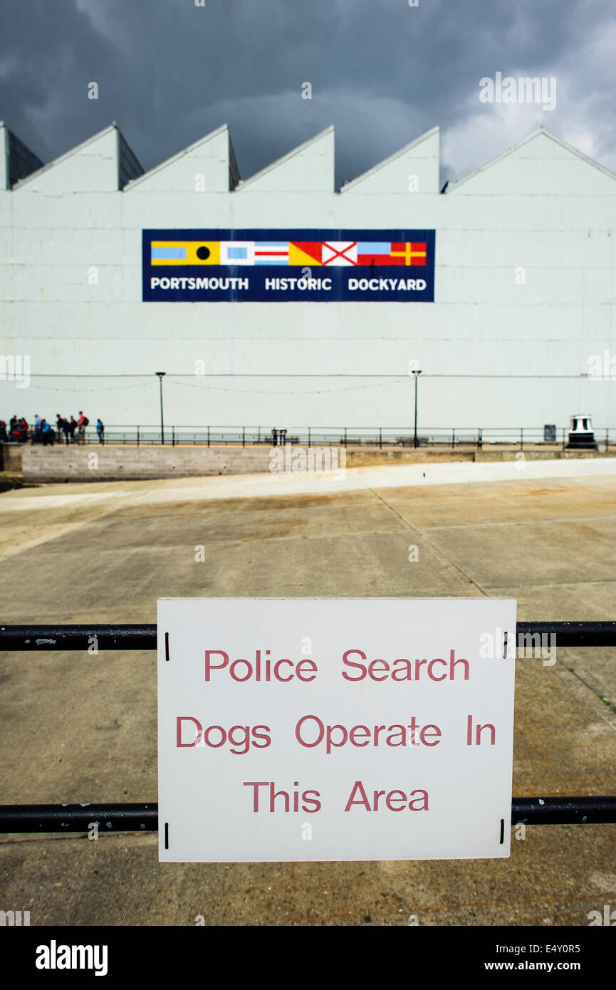 Un panneau informant les gens que les chiens de recherche de police opèrent au Portsmouth Historic Dockyard, Hampshire, Angleterre, Royaume-Uni. Banque D'Images