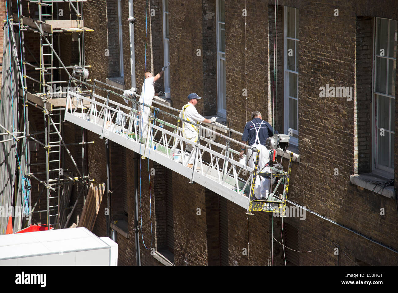 Durée du contrat de travail des peintres sur l'aile ouest de Somerset House dans le centre de Londres Royaume-uni suspendu d'un berceau Banque D'Images