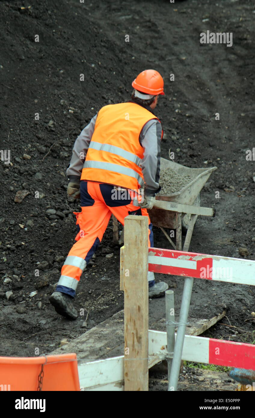 Workers pushing wheelbarrow Banque D'Images