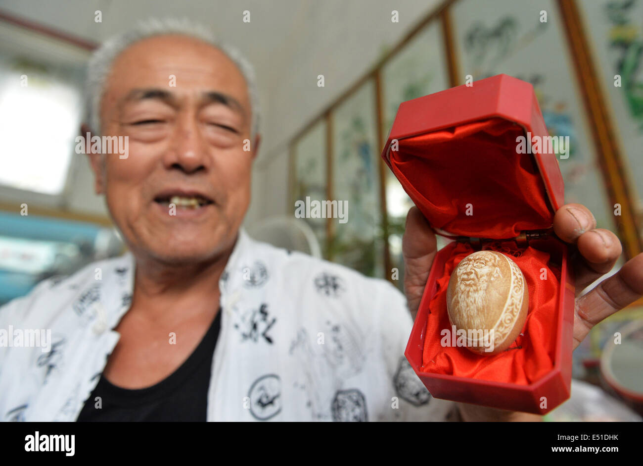 Shijiazhuang, Province de Hebei en Chine. 17 juillet, 2014. Huang Zhankui, un agriculteur de l'Yangjiatun village de Tangshan city, montre son premier œuf de l'artisanat de sculpture, portrait de l'artiste contemporain chinois Qi Baishi, à Tangshan, Province de Hebei en Chine du nord, le 17 juillet 2014. Huang, 70 ans, a étudié la sculpture d'oeufs pendant 10 ans dans ses loisirs. © Ascott Li/Xinhua/Alamy Live News Banque D'Images