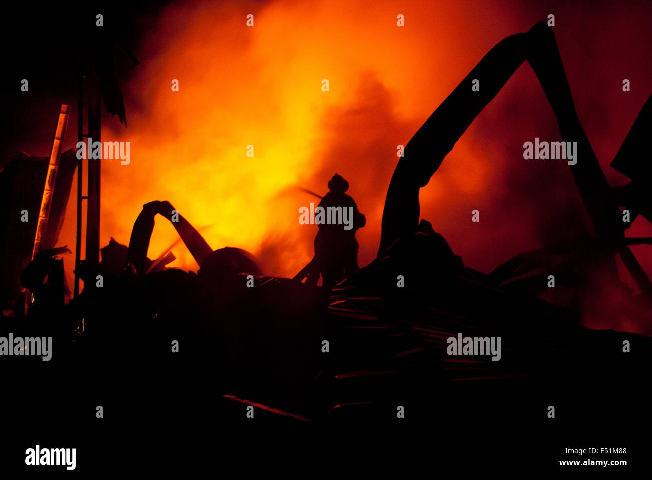 Silhouette de pompiers la lutte contre un feu faisant rage Banque D'Images