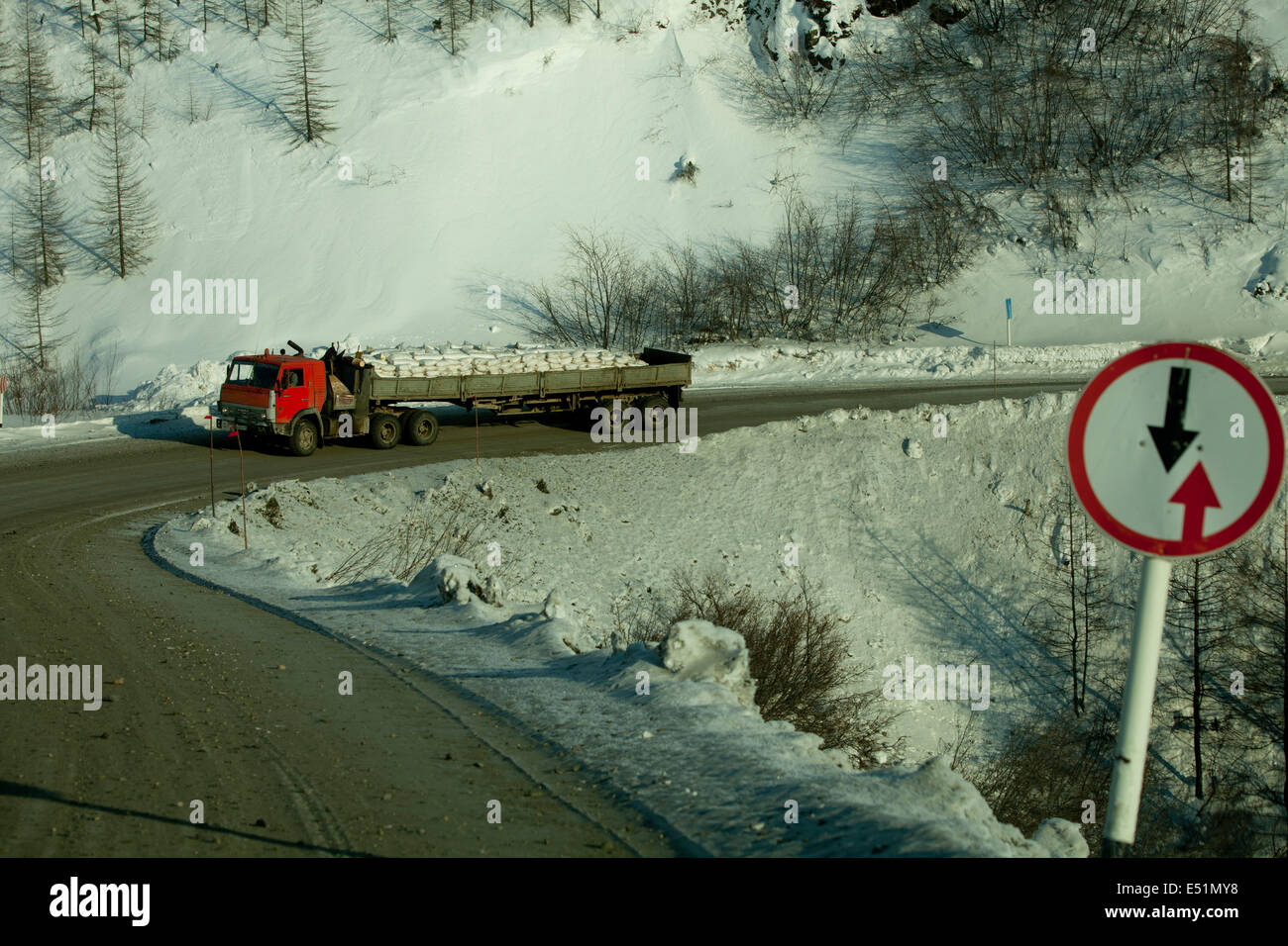 Route de montagne neige camion angle signe de danger Banque D'Images