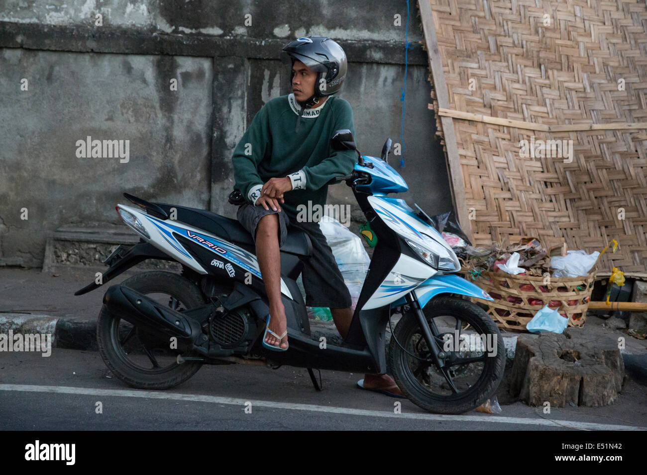 Jimbaran, Bali, Indonésie. Jeune homme sur sa moto, le mode de transport le plus populaire à Bali. Banque D'Images