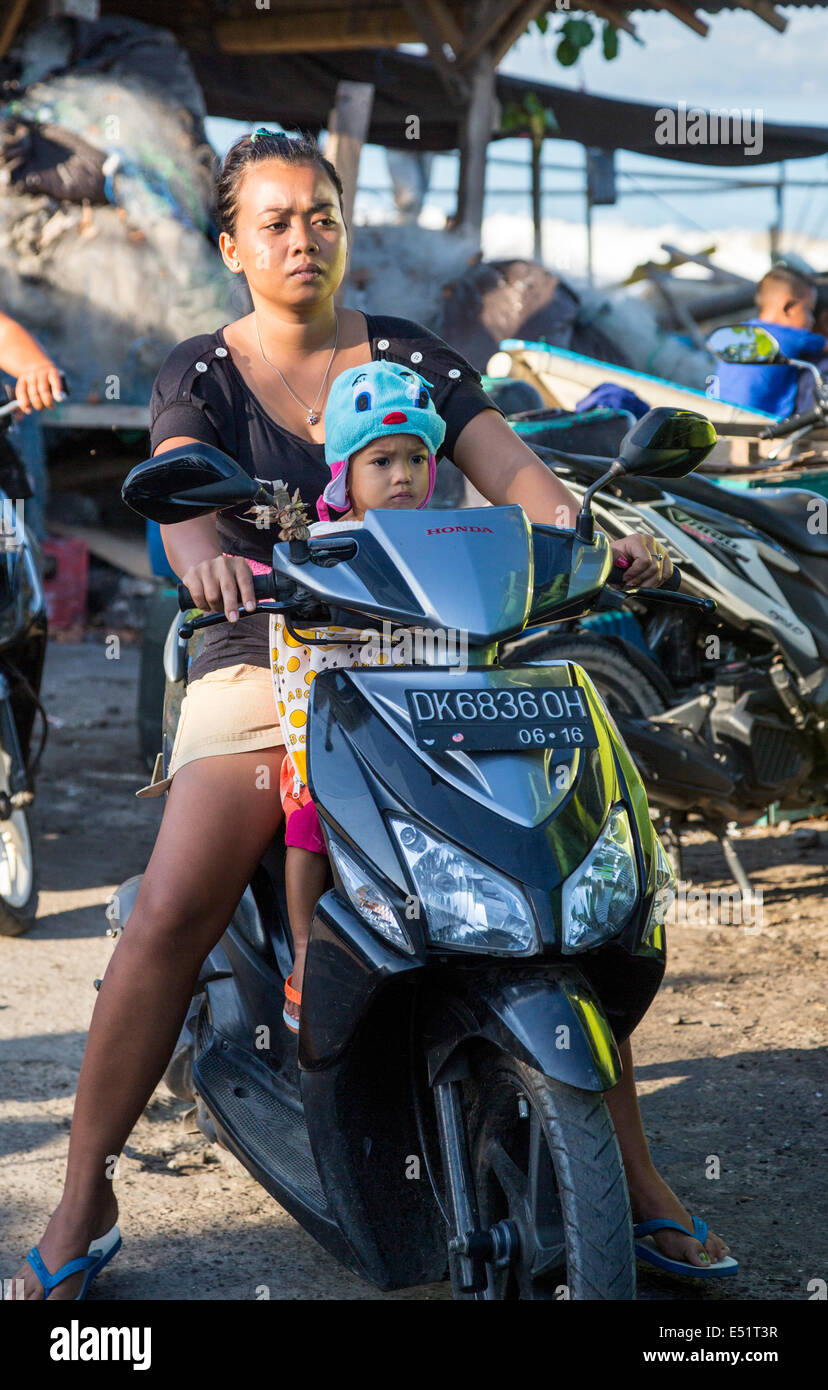 Jimbaran, Bali, Indonésie. Mère et fille Équitation Moto, pas de casques. Banque D'Images