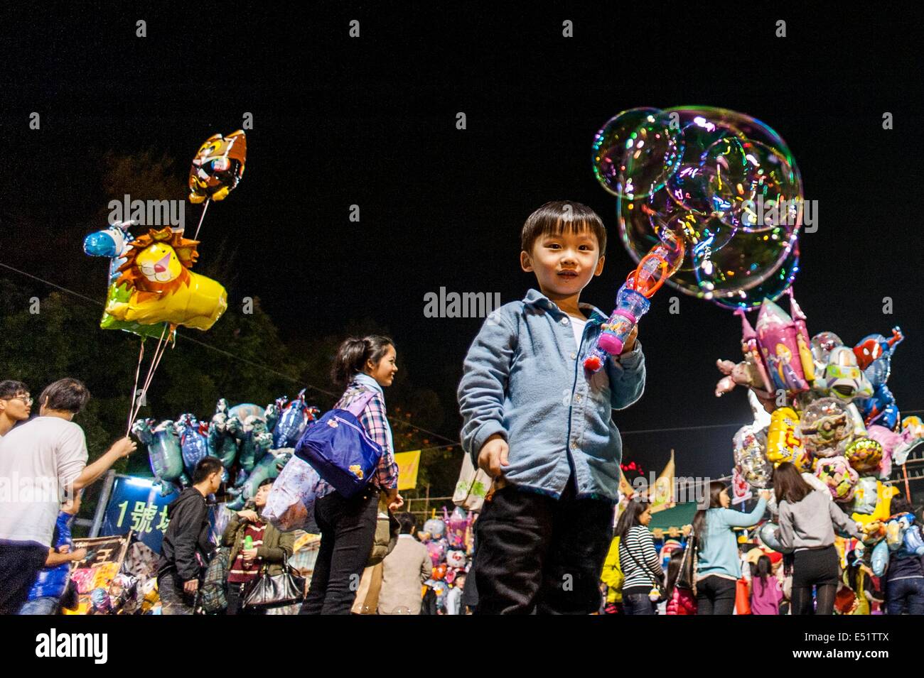 Un enfant joue avec des bulles de savon au marché aux fleurs affiché pour le Nouvel An lunaire que la Chine se prépare pour l'année de Banque D'Images