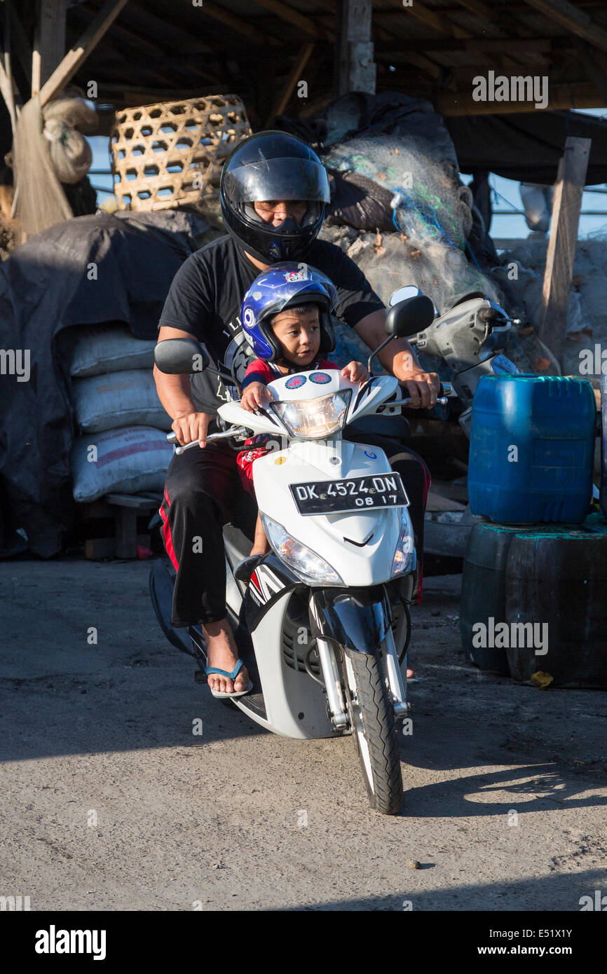 Jimbaran, Bali, Indonésie. Père et Fils sur moto, avec un casque. Banque D'Images