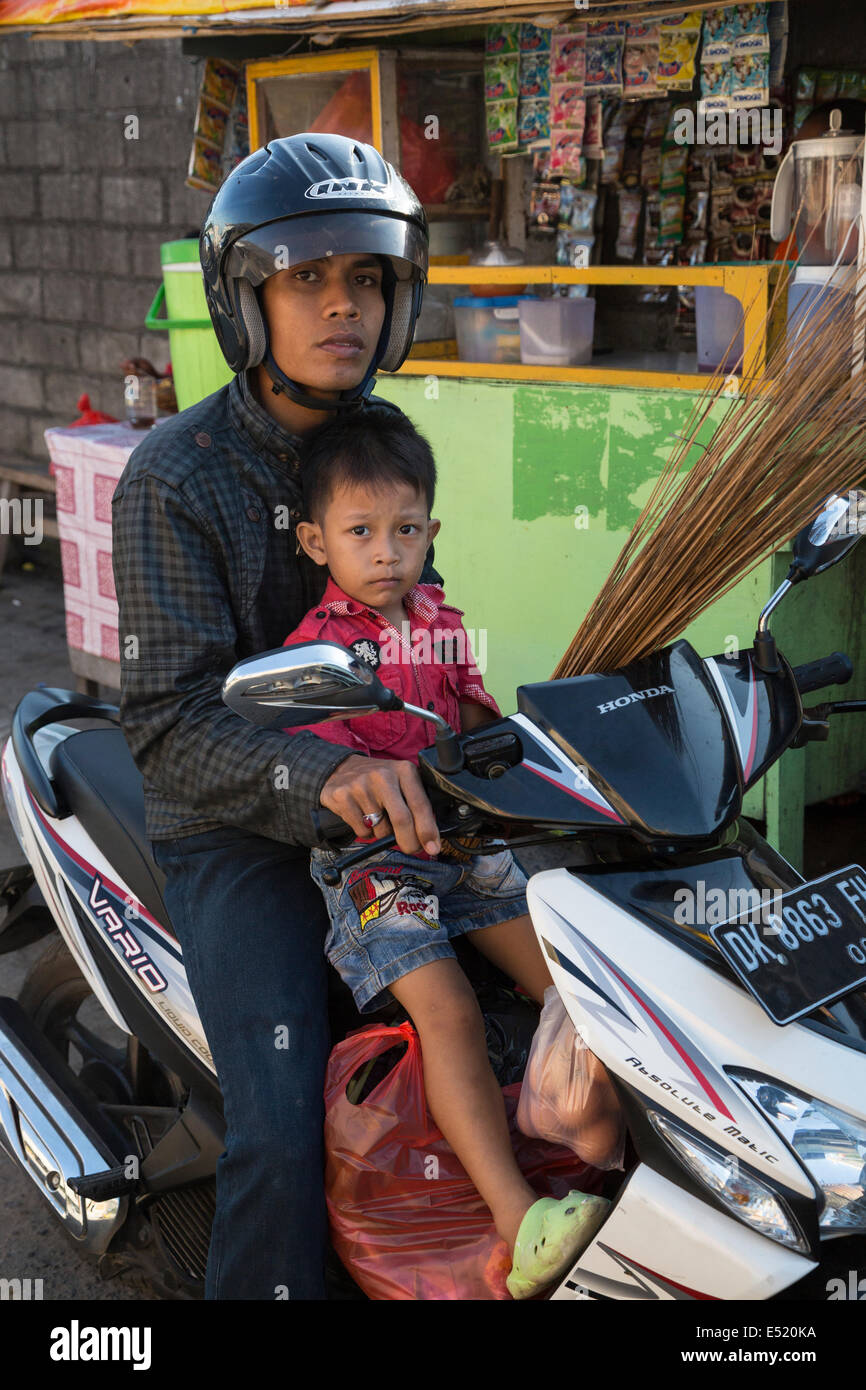 Jimbaran, Bali, Indonésie. Jeune homme et jeune garçon sur moto, pas de casque sur garçon. Banque D'Images